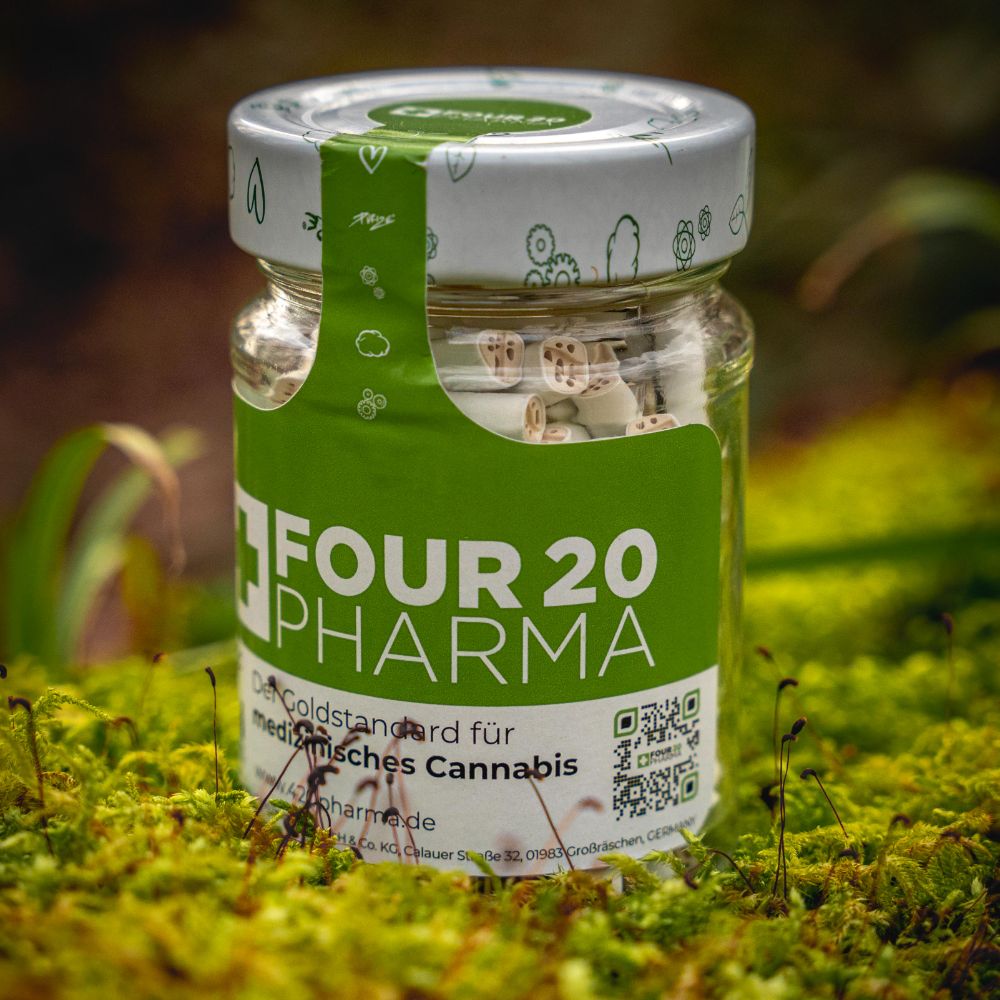 Four 20 Pharma Aktivkohlefilter im Glas auf Walduntergrund