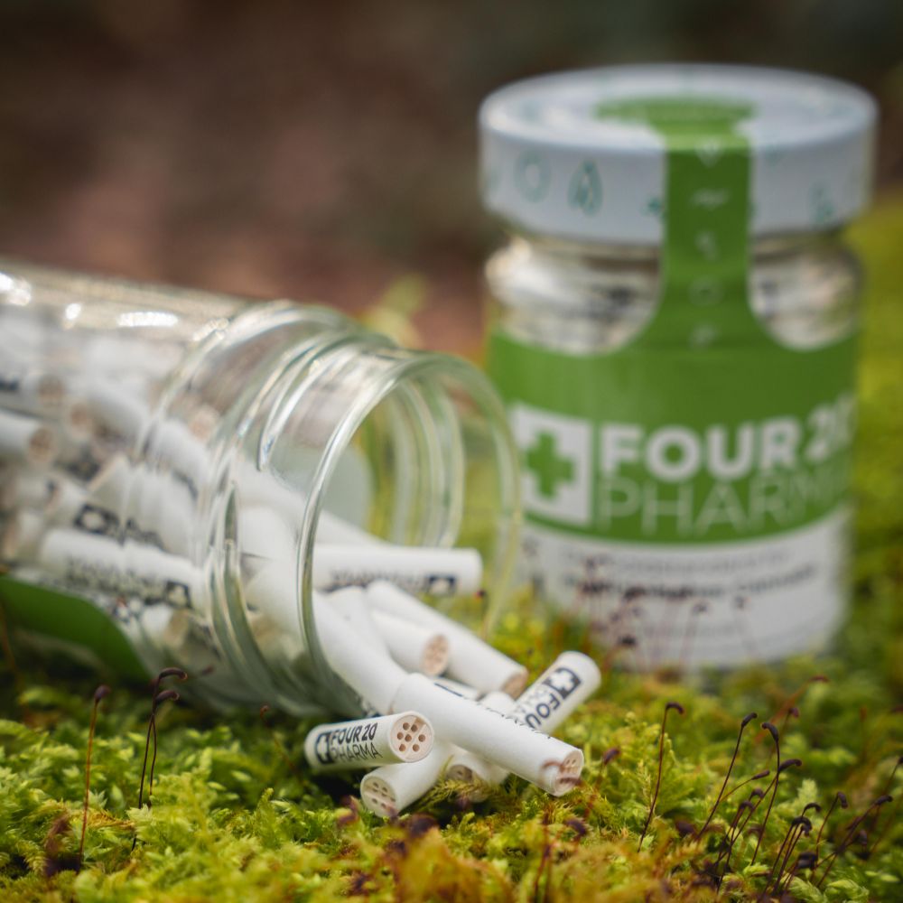 Four 20 Pharma Aktivkohlefilter im Glas auf Walduntergrund