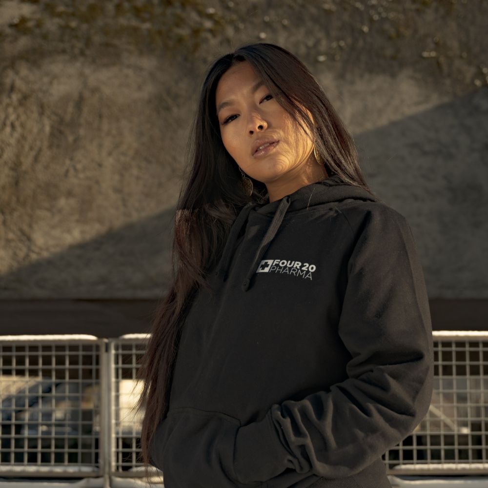 Weibliches Model mit schwarzem Four 20 Pharma Hoodie
